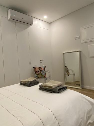 a white room with a bed and a mirror at Daisy Street Guesthouse in Braga