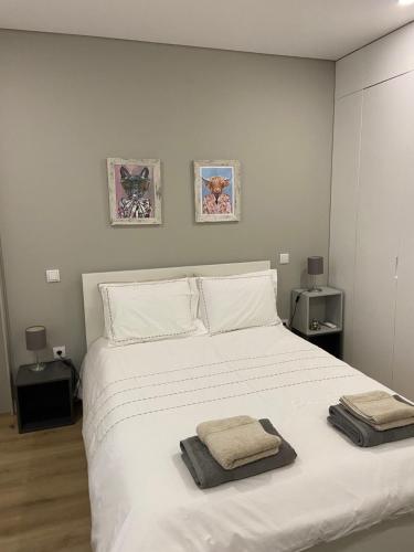 a bedroom with a white bed with two towels on it at Daisy Street Guesthouse in Braga