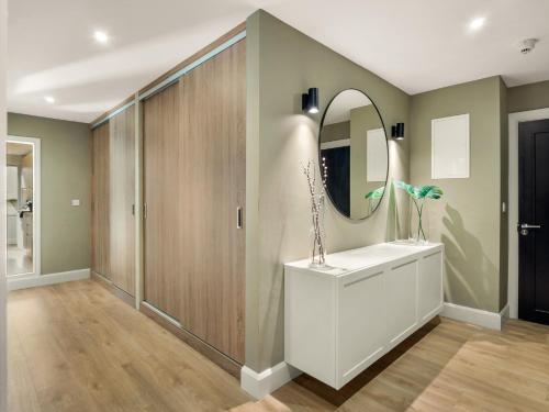 a bathroom with a mirror and a white sink at The Town Place Clifden Boutique Apartments in Clifden