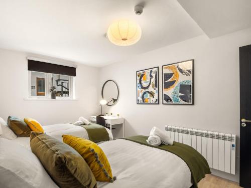 a bedroom with two beds and a mirror at The Town Place Clifden Boutique Apartments in Clifden