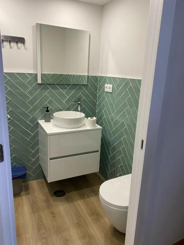 a bathroom with a sink and a toilet and a mirror at Daisy Street Guesthouse in Braga