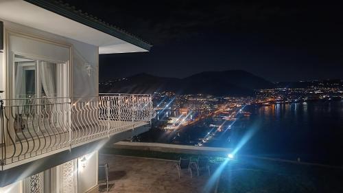 a balcony with a view of a city at night at Relais Tiaré Bed and Breakfast in Bacoli