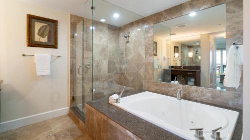a bathroom with a tub and a glass shower at 523 Mariners Club in Key Largo