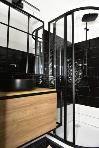 a bathroom with a sink and glass walls at Tornácos Vendégház Kőröshegy in Kőröshegy