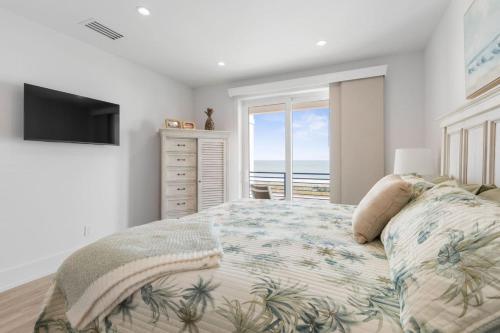 a bedroom with a bed with a view of the ocean at Sunkised Sands Flagler Beach in Flagler Beach