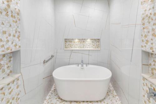 a white bathroom with a white tub in it at Sunkised Sands Flagler Beach in Flagler Beach