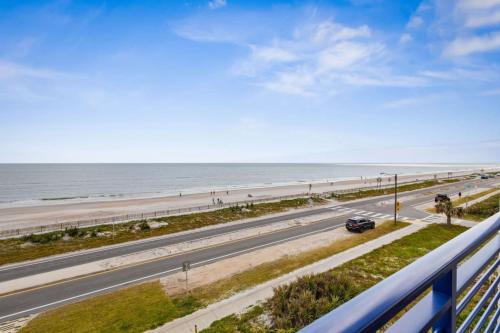a road next to the beach with a car on it at Sunkised Sands Flagler Beach in Flagler Beach