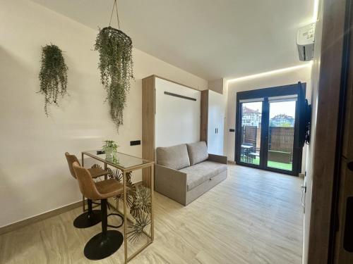 Una sala de estar con un sofá y una mesa de cristal. en Flower Deluxe 2 Estudio Jardin 6082A, en Noja