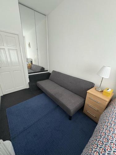 a room with a couch and a bed and a mirror at Liberty Guest House in Liverpool