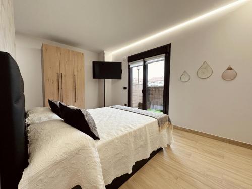 a white bedroom with a bed and a window at Flower Deluxe Bajo con Jardin 6083 in Noja
