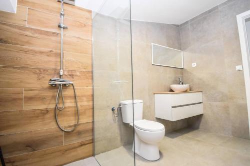 a bathroom with a toilet and a glass shower at Sweetstaybykw Moderna Casa Campo con Piscina in Asprillas