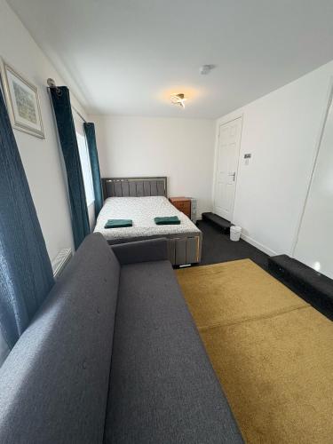 a small room with a bed and a couch at Liberty Guest House in Liverpool