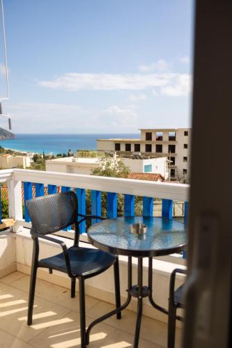 a balcony with a table and chairs and the ocean at Sofo Hotel Dhermi in Dhërmi