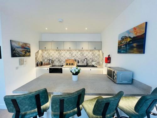 a kitchen with a counter with chairs and a tv at Bramble Apartment in Fort William