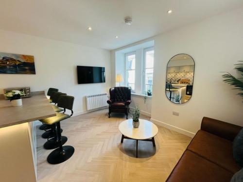 a living room with a table and a mirror at Bramble Apartment in Fort William