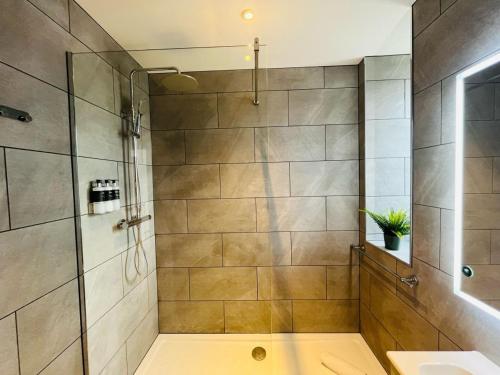 un baño con ducha y lavabo en Bramble Apartment, en Fort William