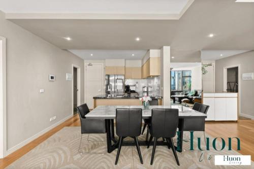 a kitchen and dining room with a table and chairs at Penthouse style 4brmx4bath apt in Melbourne