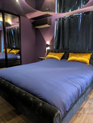 une chambre avec un grand lit avec des oreillers jaunes dans l'établissement L'instant plaisir, à Bettant