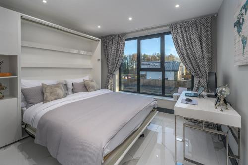 une chambre avec un lit, un bureau et une fenêtre dans l'établissement Luxury 7 Bed Durham Mansion Pool, Spa, Cinema, à Durham