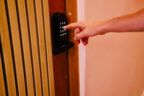 a persons hand unlocking a door with a phone at Room 16 Grand King Suite with Desk & Sofa Bed in San Juan
