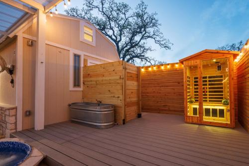 a deck with a tub and a wooden fence at Secluded Luxury Couples cabin Sauna Pool in Wimberley