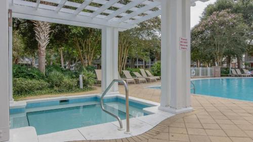 a swimming pool with a pergola next to a swimming pool at Grand Sandestin at Sandestin Resort by Tufan in Destin