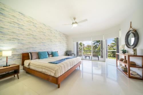 une chambre avec un lit et une grande fenêtre dans l'établissement Luxury 2 BR Condo with tub & Infinity Pool - Beach Side At Mareazul - Sirenita G, à Playa del Carmen