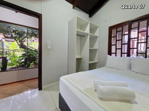 a bedroom with a large white bed with a window at 7 quartos - ótima área de lazer prox Centro e Cataratas in Foz do Iguaçu
