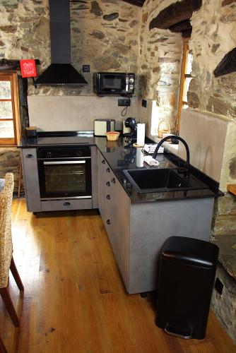 a kitchen with a sink and a stove at Casal do Amor in Lousã