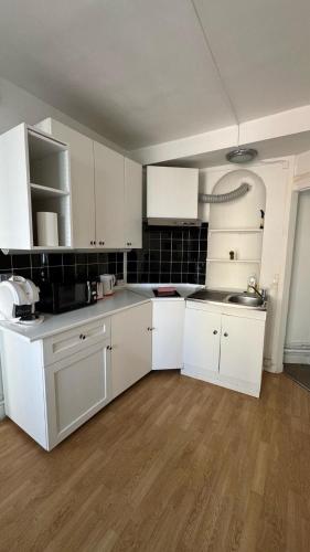 une cuisine vide avec des placards blancs et un évier dans l'établissement Appartement a Paris, à Paris
