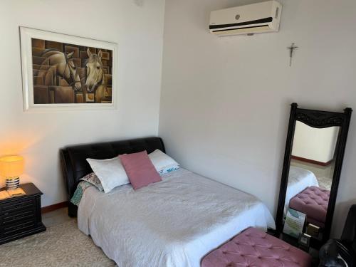 a bedroom with a bed and a mirror at Hacienda Villa Hermelina-Casa Campestre in Turbaco