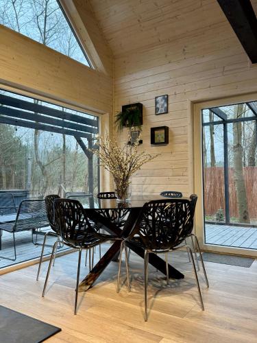 a dining room with a glass table and chairs at Greenwood I - Dom z Jacuzzi i furtką do lasu in Tuliska