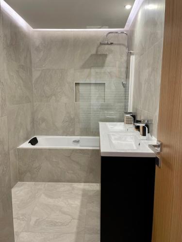 une salle de bain avec un lavabo et une baignoire dans l'établissement Magnifique villa jacuzzi plage 15 min a pied, à Sainte-Maxime