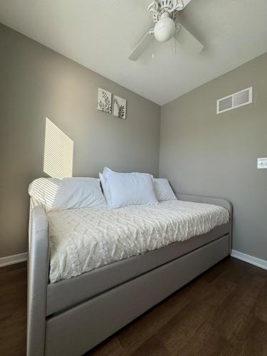 a bed in a room with a ceiling fan at Newly built 3 level home 2 minute drive to UCM in Warrensburg