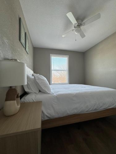 a bedroom with a bed with a ceiling fan and a window at Newly built 3 level home 2 minute drive to UCM in Warrensburg