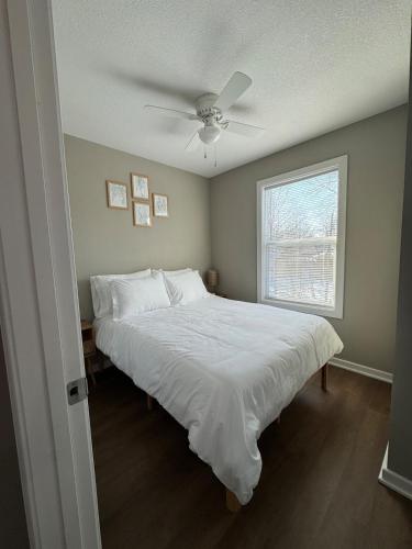 a bedroom with a large bed with a ceiling fan at Newly built 3 level home 2 minute drive to UCM in Warrensburg
