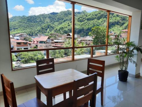 a dining room with a table and chairs and a large window at Hotel Wismont Piñales in La Merced