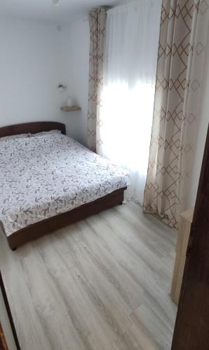 a bedroom with a bed and a wooden floor at Seosko turističko domaćinstvo Stanković in Arandjelovac
