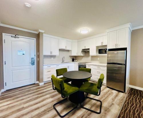 a kitchen with a table and chairs and a refrigerator at Prestige Radium Hot Springs Resort, WorldHotels Crafted in Radium Hot Springs