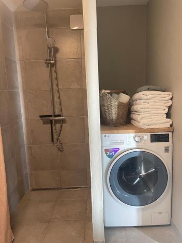 a washing machine in a bathroom with a shower at Baekgaarden 3 rooms Apartment - old farm house in Odense