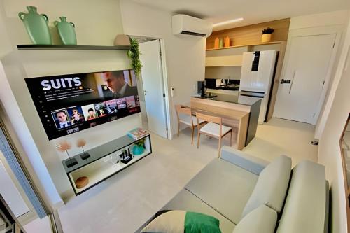 a living room with a couch and a tv on a wall at Capitães de Areia in Salvador