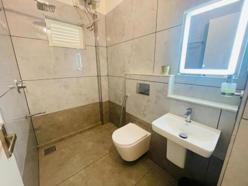 a bathroom with a toilet and a sink and a window at Mountain Serenity Meppadi, Wayanad in Kalpetta