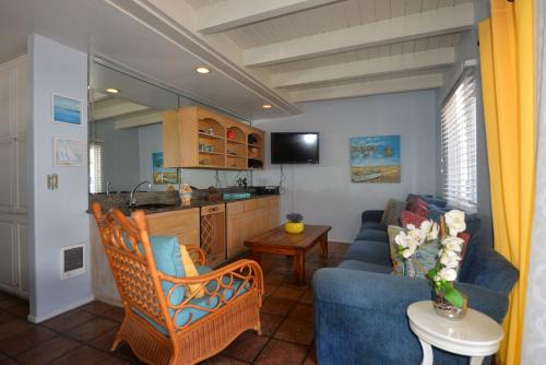 a living room with a blue couch and a kitchen at 211CL 211 Claressa in Avalon