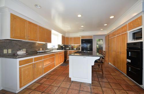 a large kitchen with wooden cabinets and black appliances at 211CL 211 Claressa in Avalon