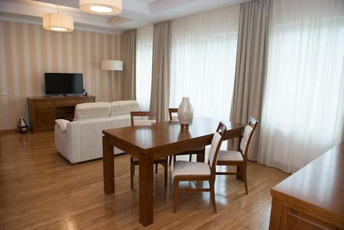 a living room with a table and chairs and a couch at Hotel TTS**** Spa&Wellness Covasna in Covasna
