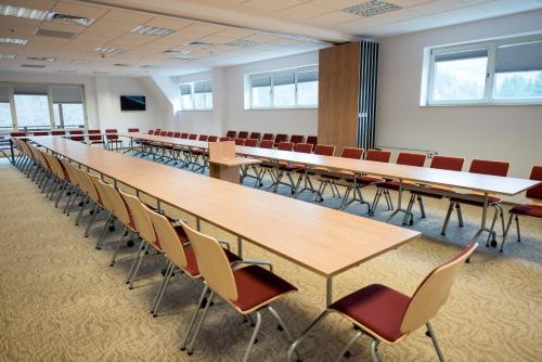 a conference room with long tables and chairs at Hotel TTS**** Spa&Wellness Covasna in Covasna