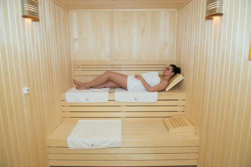 a woman is laying in a sauna at Hotel TTS**** Spa&Wellness Covasna in Covasna