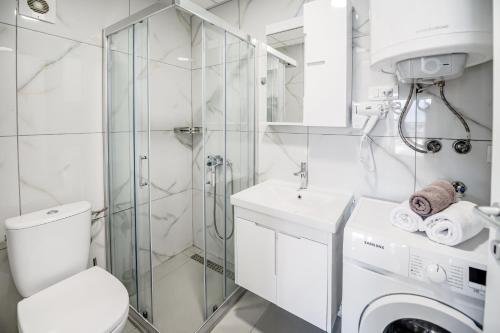 bagno bianco con lavatrice e doccia di Luxury Flat in Ohrid Center Near Lake & Old Town a Ohrid