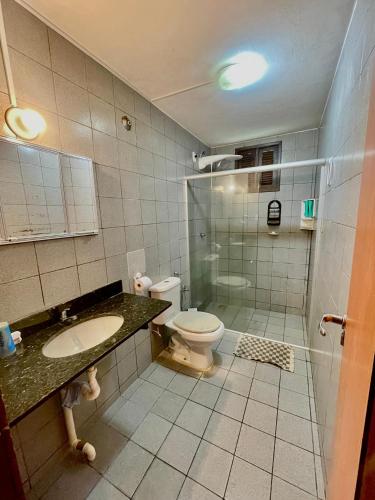 a bathroom with a toilet and a sink and a shower at Casa do Billy in Pipa