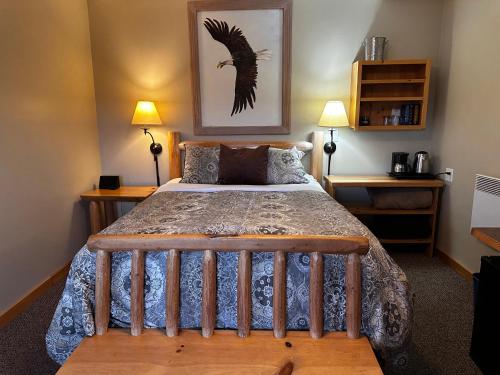 a bedroom with a bed with a wooden bed frame at Chewuch Inn & Cabins in Winthrop